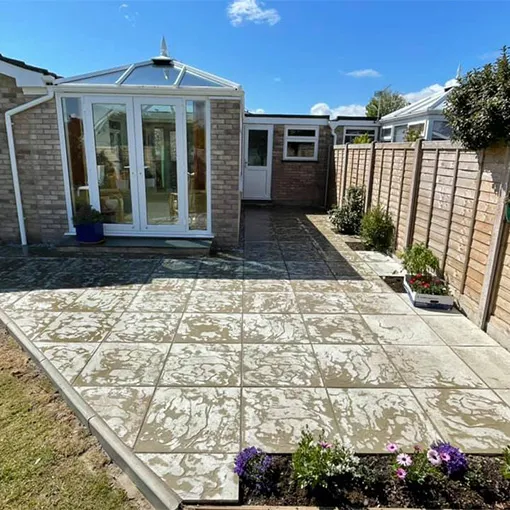 a backyard with a patio and a brick wall