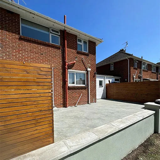 a brick house with a wooden fence and a wooden gate