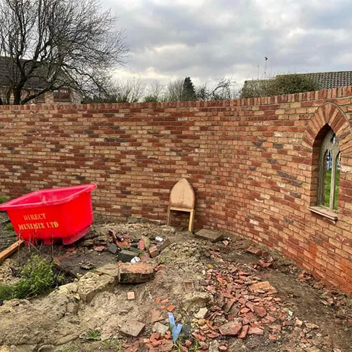 a red boat sitting on top of a pile of rubble