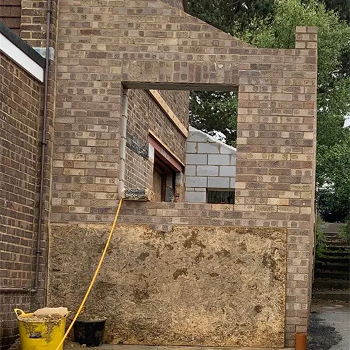 a yellow fire hydrant sitting next to a brick building