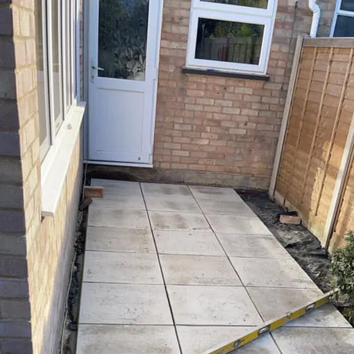 a patio being laid in front of a house